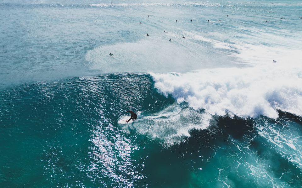 A surfer on a wave at El Cotillo, Fuerteventura, seen from above.