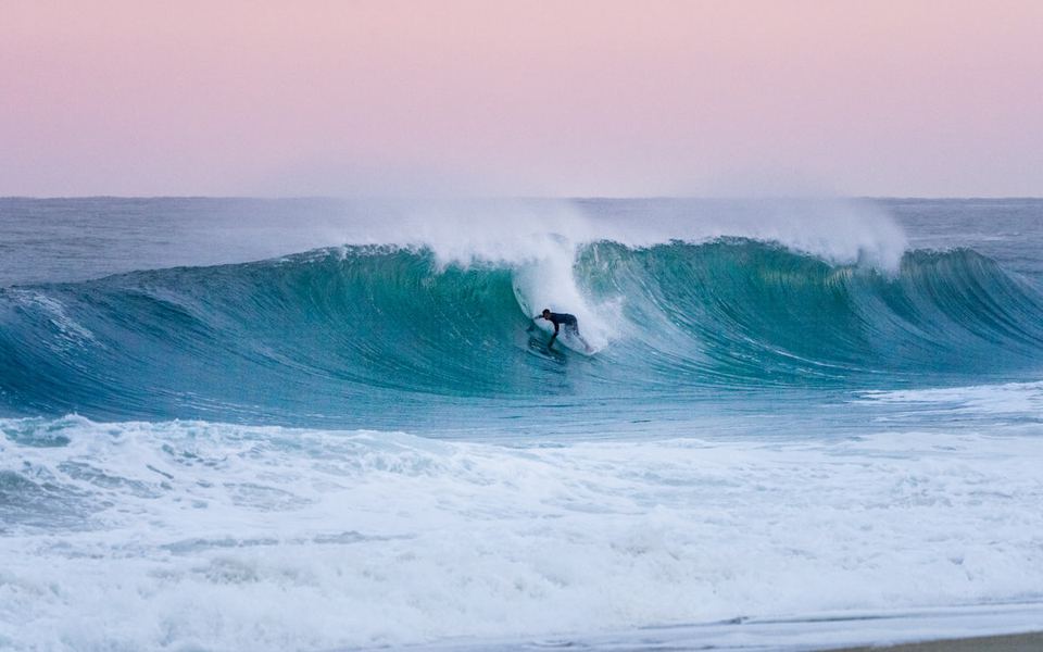 A surfer inside a hollow beach-break barrel at Hossegor, France.
